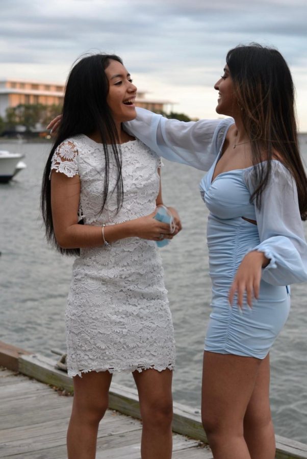 Seniors Yolita Barreto and Anya Dhuria prepare to pose in their dresses at the Georgetown waterfront.