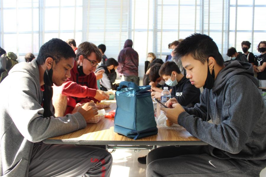 Juniors Omar Yoosef, Joshua Bennett and Jagger Yung eat lunch in the cafeteria. Administrative contact tracing does not include lunch, though it is one of the times when students are allowed to remove masks while in close proximity, giving way to more exopsure.