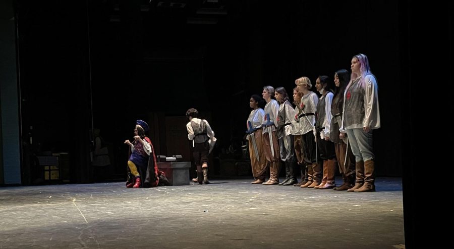 Cast members practice on stage with costumes on dress rehearsal.