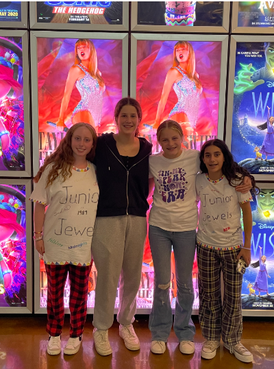 (From left) Freshmen Becca Dodek, Ye'ela Zilberman, Leila Singer and Hannah Vernenkar pose in front of "Taylor Swift: The Eras Tour" movie posters. "You could tell that everyone loved Taylor Swift a lot and everybody was jumping up and down like we were at the concert," Dodek said.