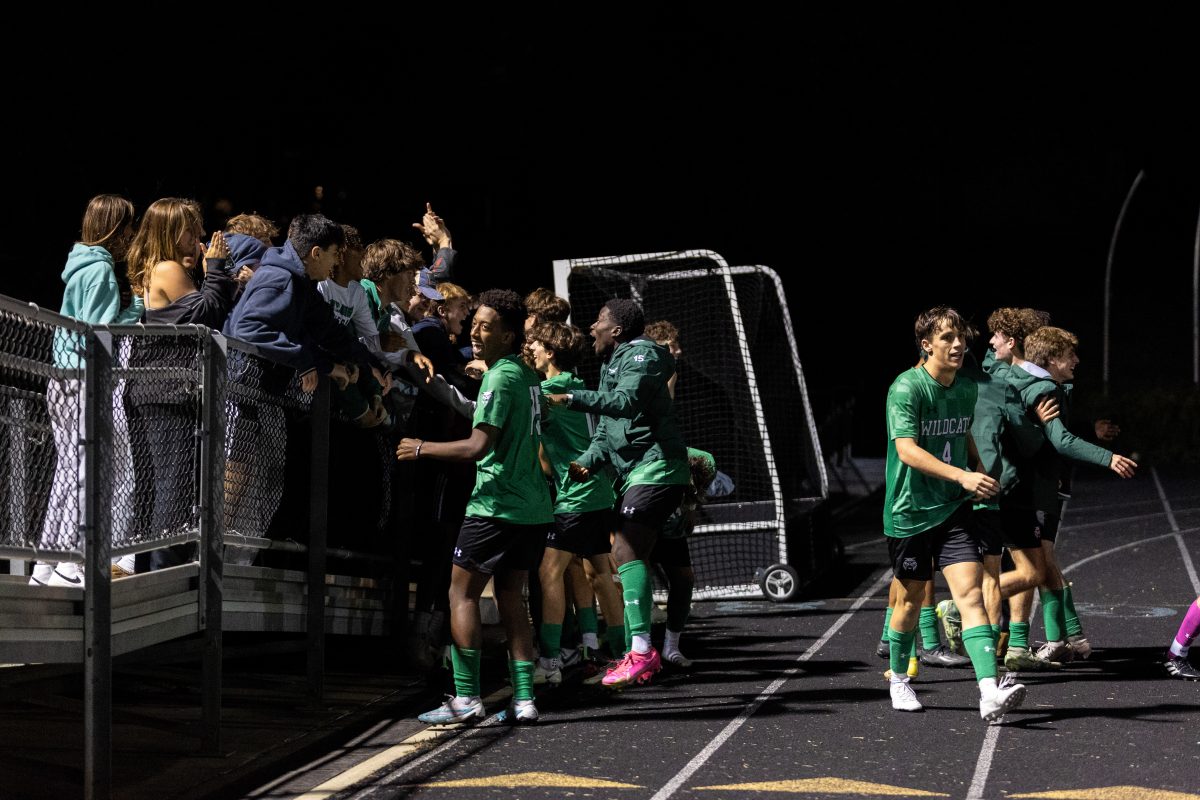 The Boys soccer team celebrates their late goal with the Madcows student section. The yelling and cheering could be heard from all the way across the bleachers.