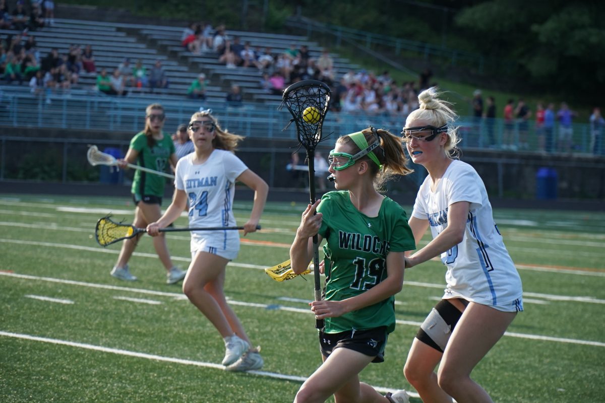 Junior Elsa Santighian cradles the ball down the field as Kristina Einberg attempts to retrieve the ball. The Cats had a tough loss of 11-7 to the Whitman Vikings.