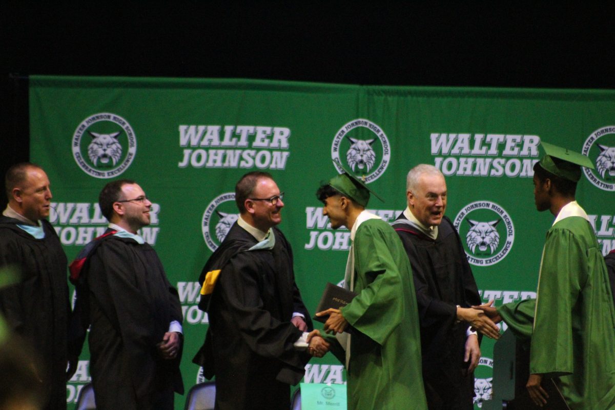 Waqif Waziri shakes hands with honorary guests after getting handed his diploma he had been very excited to receive.