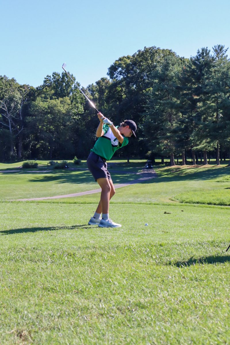 Freshman Owen Struzzerio winds up for his shot on Hole #12 a par 3. While Struzzerio's shot did not reach the green, he got up and down for par from a disadvantaged position.