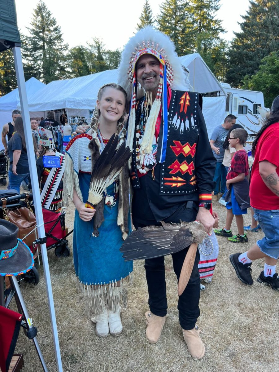 Sophomore Grace Harrington and father dress down in their regalia for powwow. Photos similar to these hang in her house with her father often reminding her of her Native ancestry. “Some people put little pilgrim decorations up on their house at Thanksgiving, we do not do that, but we do still celebrate it because it brings our family together,” Huntington said. (Courtesy Grace Harrington)