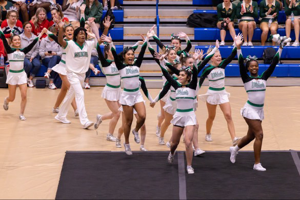 The cheer squad struts to the floor to start their routine for regionals on Nov. 2 at Harford Community College. The team spent weeks working on their routine and were proud to get the chance to perform it at regionals. “Stepping on to the mat at regionals, I felt really nervous, but I was also very excited because I wanted to show the judges all the hard work we put into the routine,” junior Lyla Cho said. (Courtesy Candice Nsoga-Mahob)