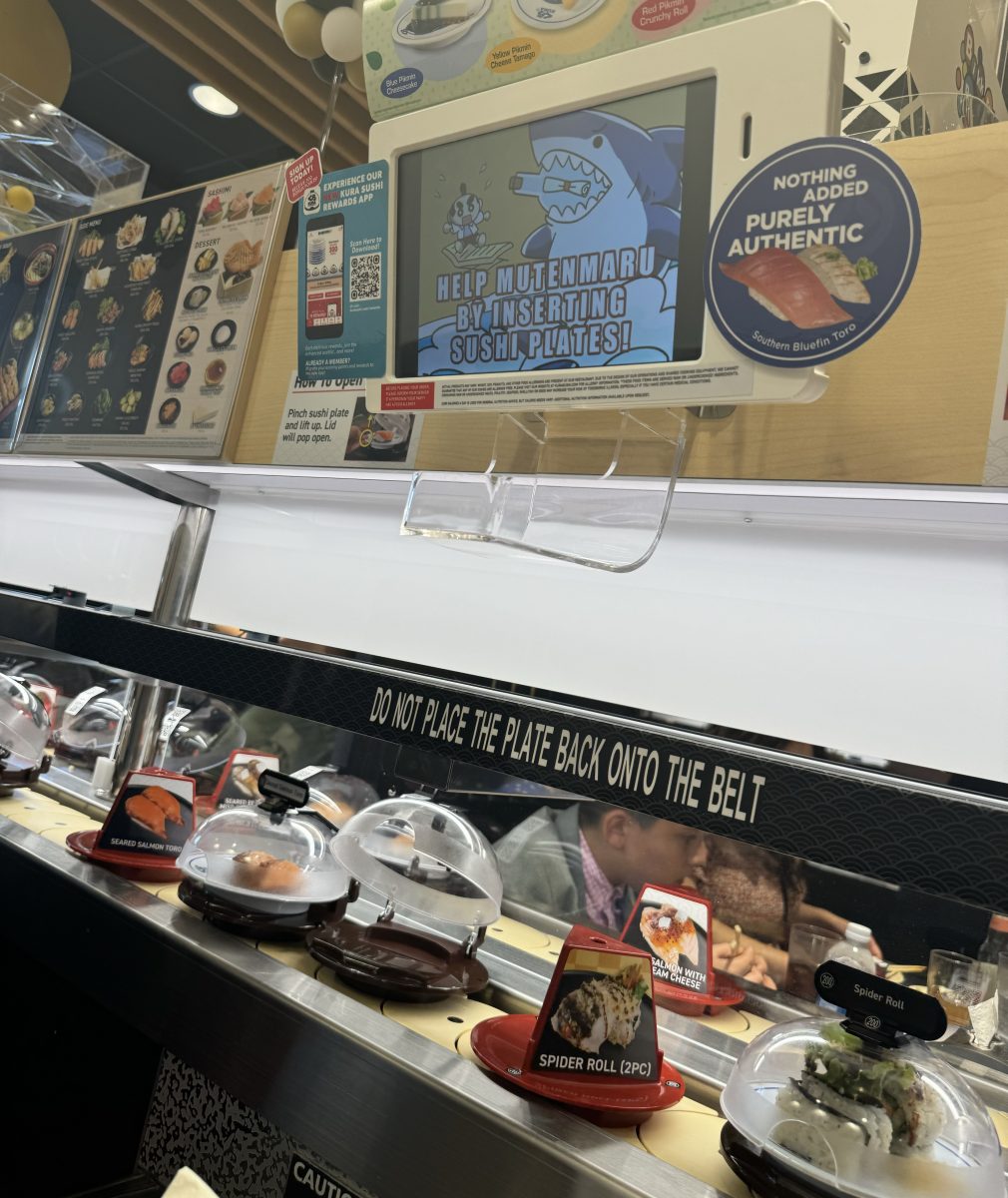 Kura Sushi's revolving conveyor belt rotates a variety of sushi and nigiri.  Meanwhile, the tablet above the table played a cartoon video urging guests to feed their empty plates into the table slot.