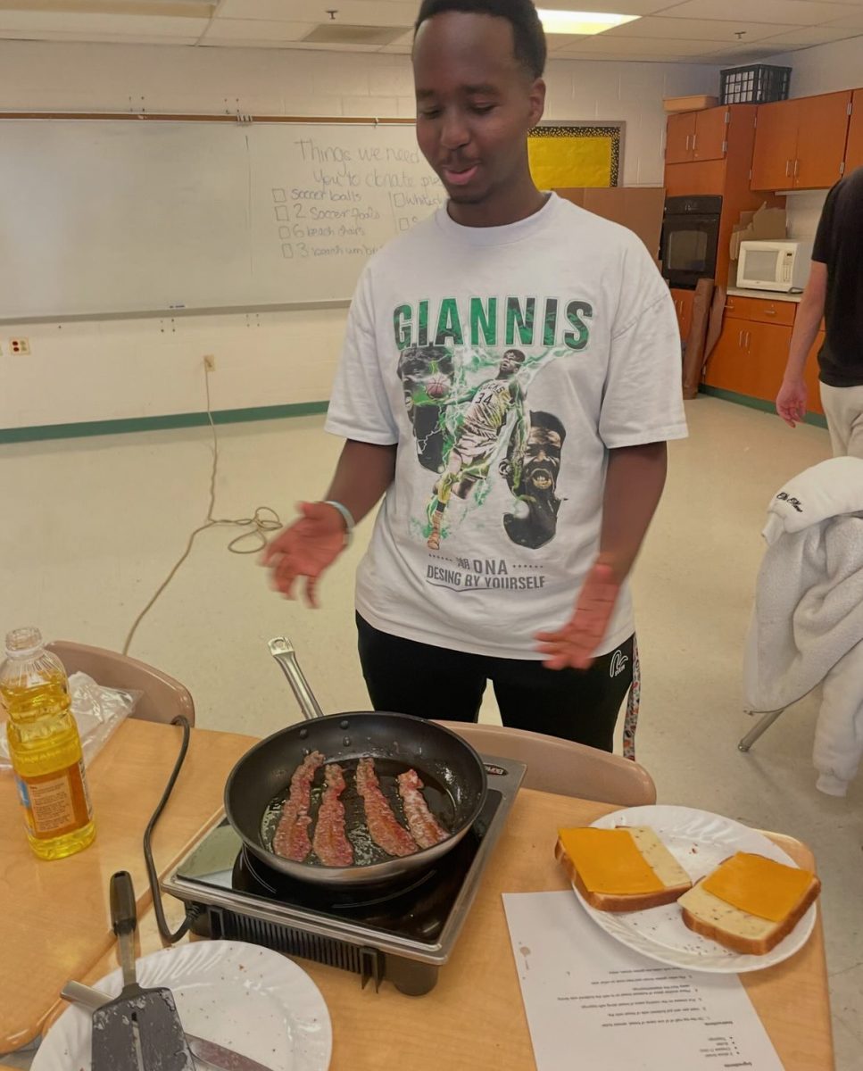 Senior Lenny Yuhi fries bacon for a grilled cheese sandwich during culinary club meeting. The club was founded this year and has made a range of foods, from pancakes to french toast. “Cooking has always been one of my favorite things to do and I was excited to join a club that involved cooking,” sophomore Kayla Mitali said. (Courtesy Guillaume Fradet)