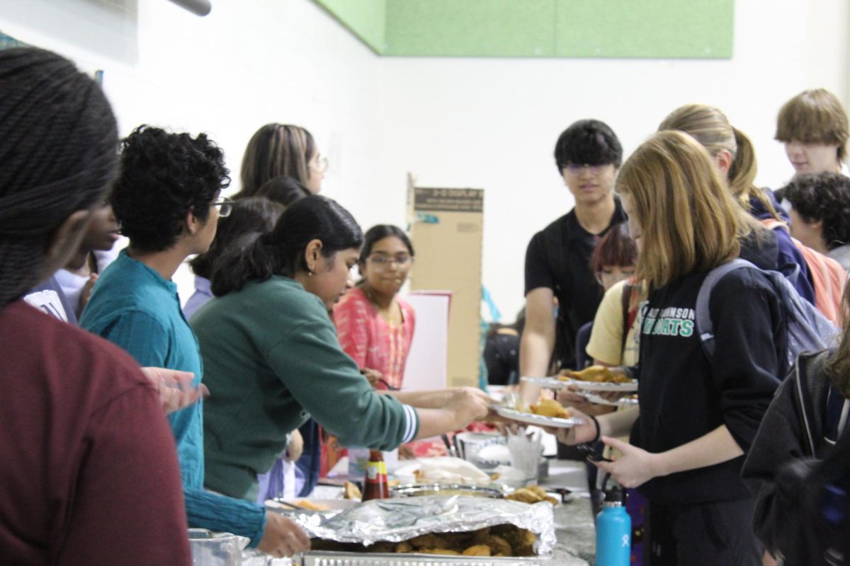 Vice President of South Asian Student Union (SASU) Jecintha Perianayagam serves samosas. "I think it's just important to emphasize our culture, our food, and to be able to share with our peers," Perianayagam said.