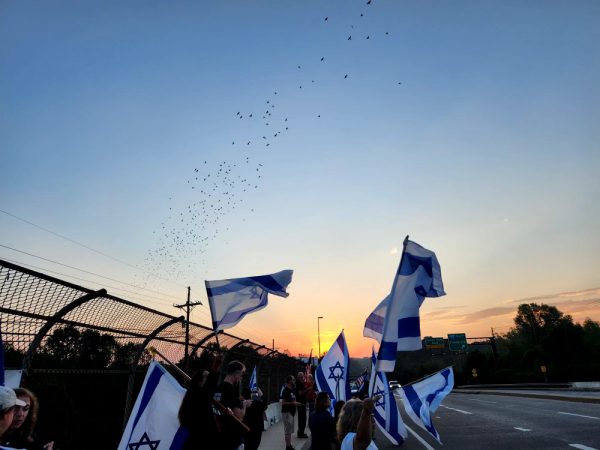 A group of Israelis in the community rally together on Montrose Bridge. They decided to gather together around 6:30 a.m., marking the exact one-year anniversary of the war. (Courtesy Liann Keren)