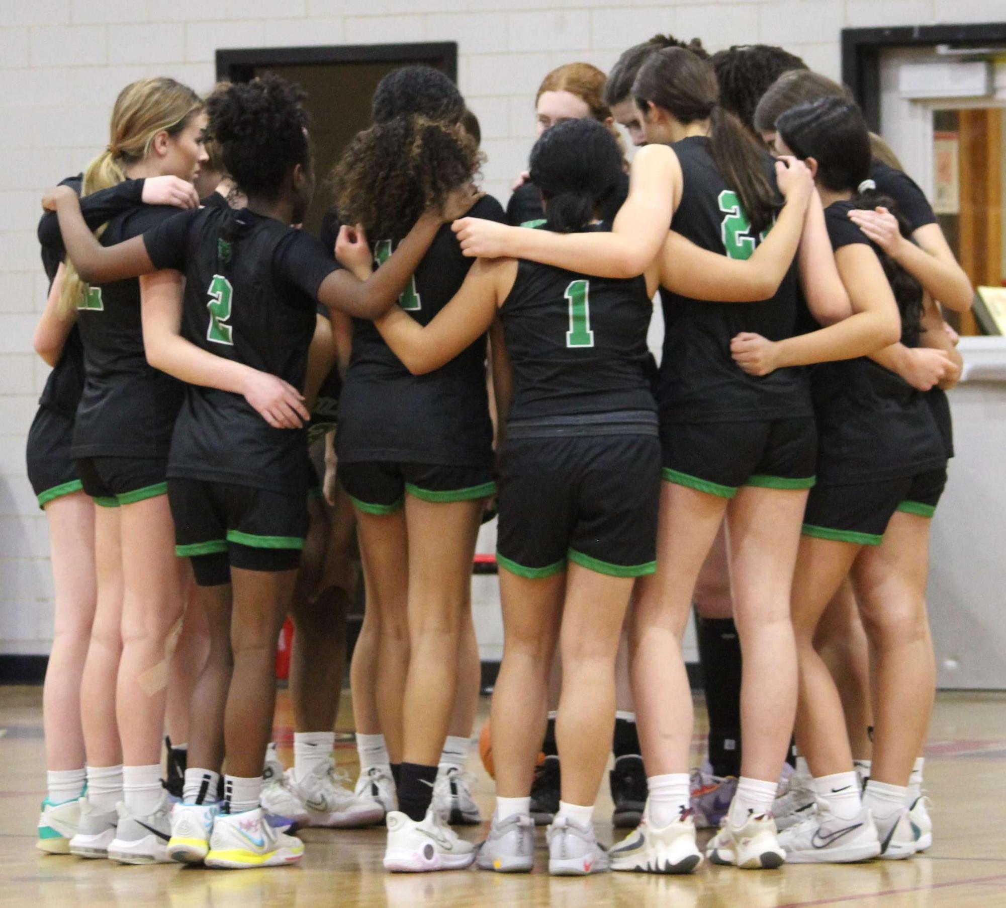 The girls' basketball team in the huddle during the 2023-24 season. The Cats hope that their team chemistry will help them in their pursuit of a deep run in the postseason. (Courtesy Mira Mann)