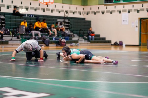 Class of '24 Emma Matalia pins down an opponent in a match last year. Matalia was one of the few girls on the team last year and has helped pave the way for future female wrestlers. (Courtesy Geoffery Prior via Lifetouch, reproduced with permission)