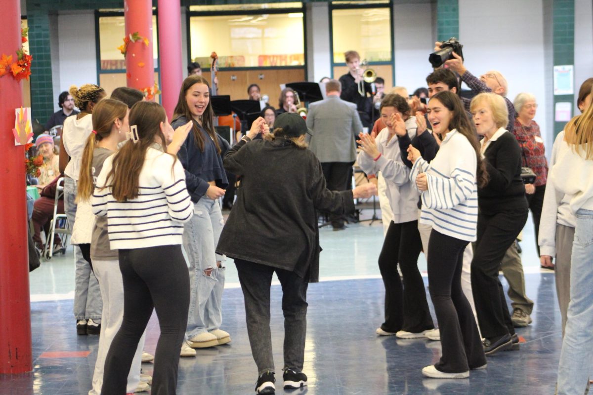 Senior citizen Sandy Bragin dances down a line of student volunteers and guests. After the meal, the dancing is a huge part of the luncheon. "We were having a ball out there on the dance floor. It’s great. We’re having a wonderful time," Bragin said.