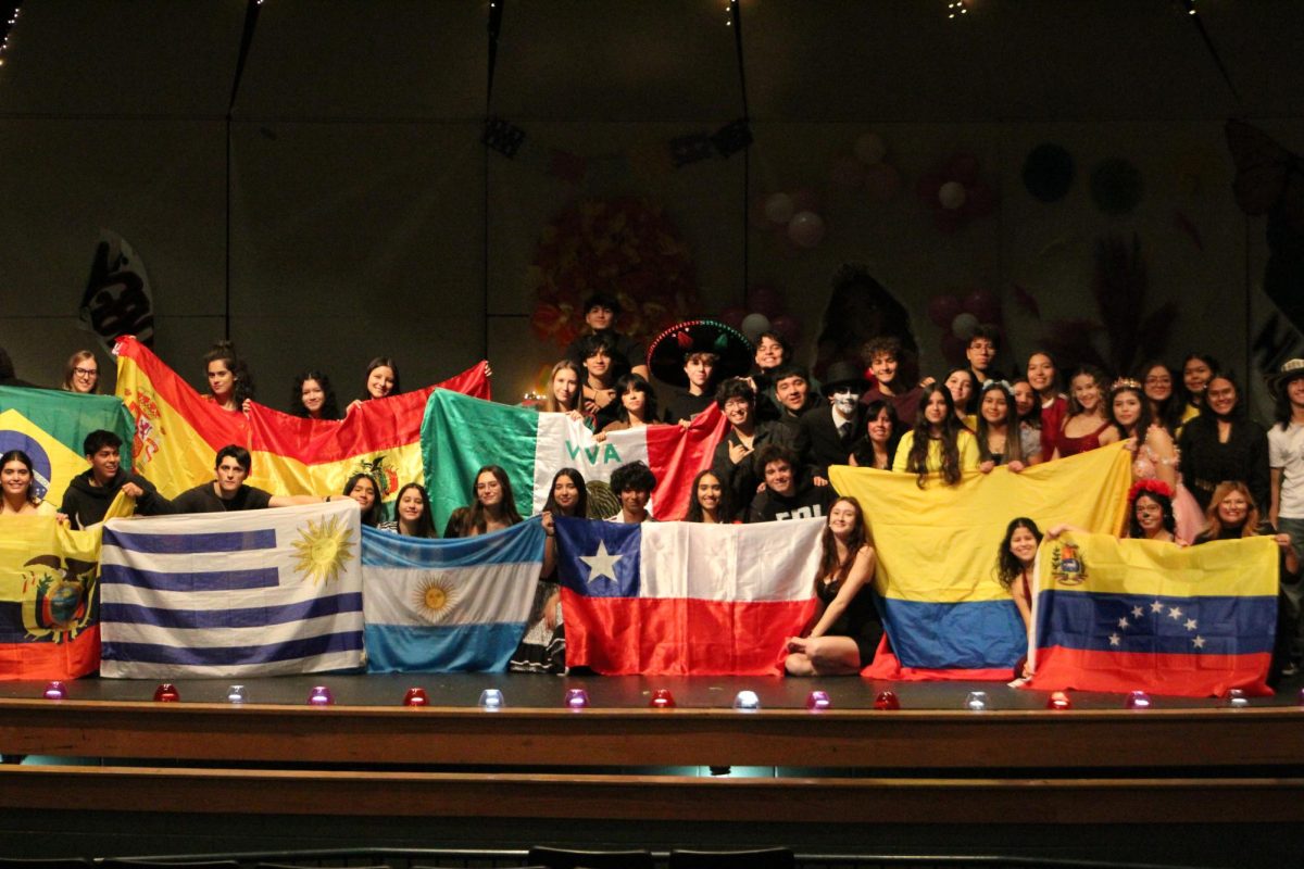 Performers and backstage crew pose for a picture at the end of the three shows. The many flags shown represented the diversity of cultures represented in the assembly.