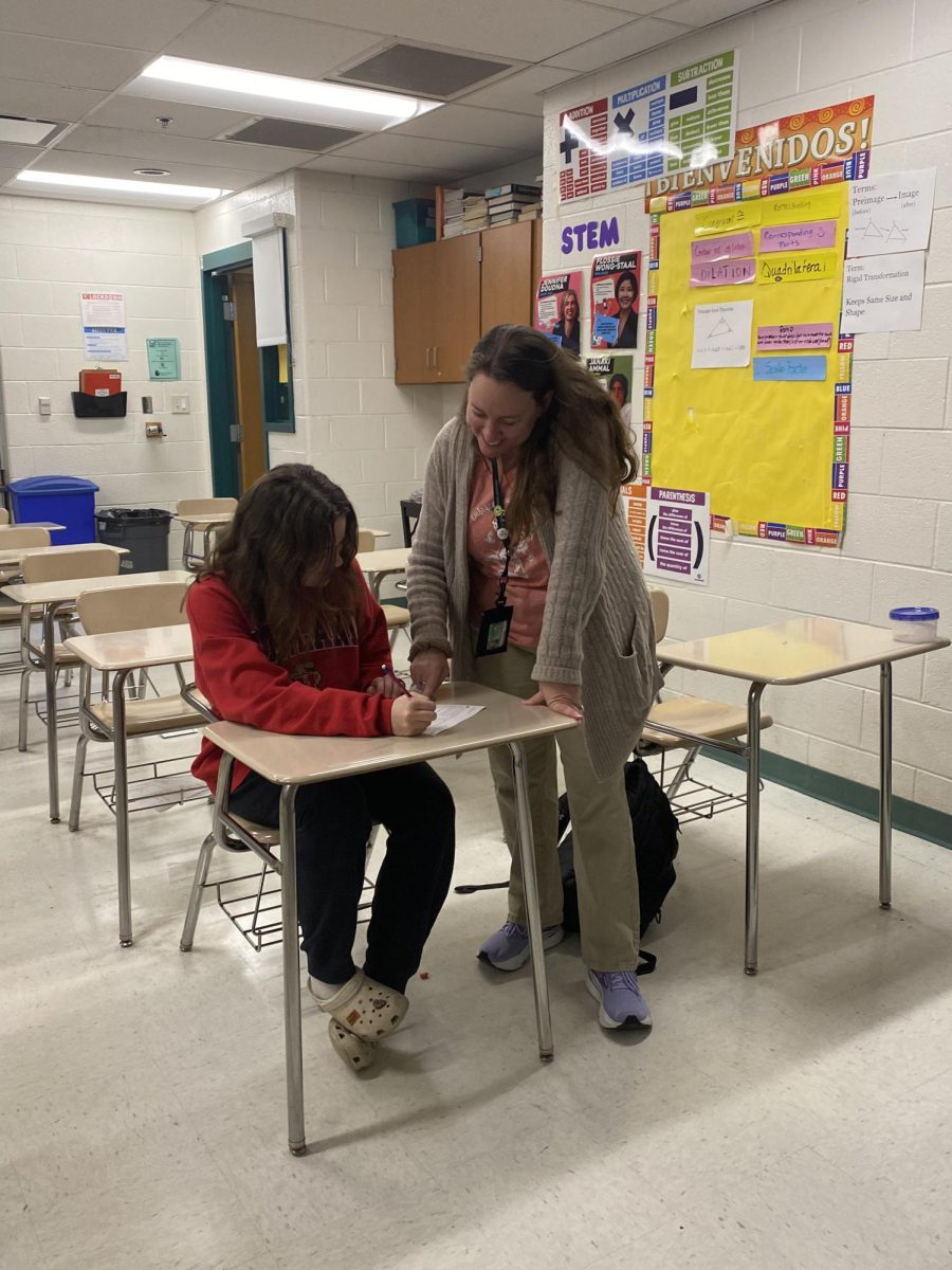 Math teacher Tricia Cooper helps junior Caroline Lasko  on a precalculus assingment during lunch. Cooper is consistently available for extra help from students as she tries to leave no student behind. “I think she has such a way to connect with students,” Math teacher Terri Bullock said.