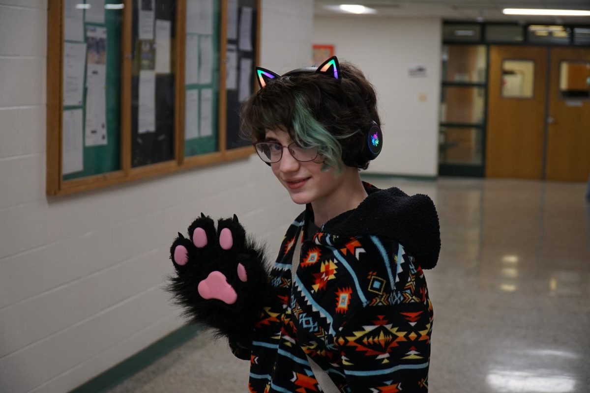 Freshman Zoe Cantatore-Fitch smiles and waves, wearing their characteristic paws and cat ear headphones. "I take them off when I’m using my laptop, because there’s really no point," Cantatore-Finch said. "The fingers are so big."