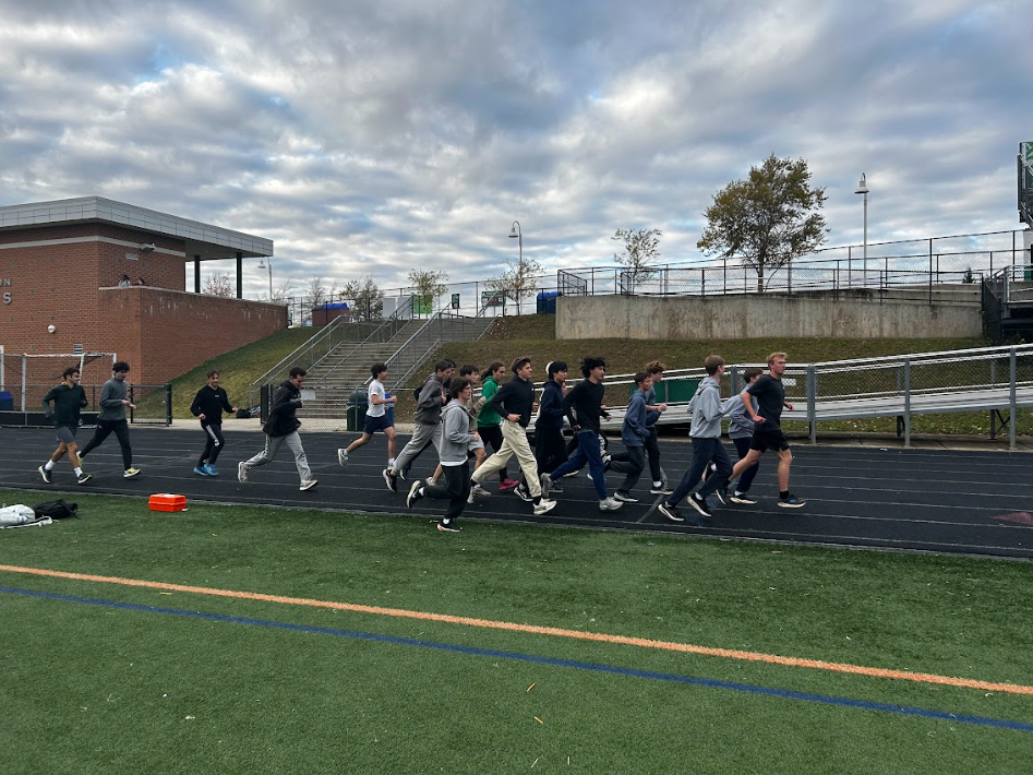 Runners start warmup laps for winter track tryouts after school. Tryouts are held every year in  November with the season closing in late March. Runners wear jogging pants and sweatshirts to protect from the cold and the wind.