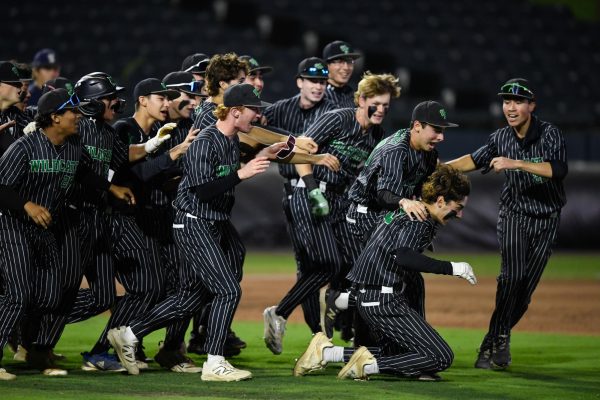 The Walter Johnson High School baseball team celebrates around senior Shaun Rudick, who hit the walkoff single to win the 4A State Championship for the Wildcats on Friday night. The Wildcats beat the Urbana Hawks 7-6 to clinch their first-ever state championship. (Photo by Hannah Foslien, reproduced with permission)