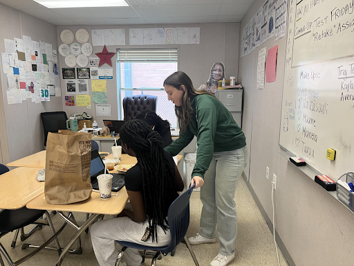 AP Stat and Algebra 2 teacher Laura Brager helps students complete their math assignments during lunch. Willingness to support students is a trait that good teachers have.