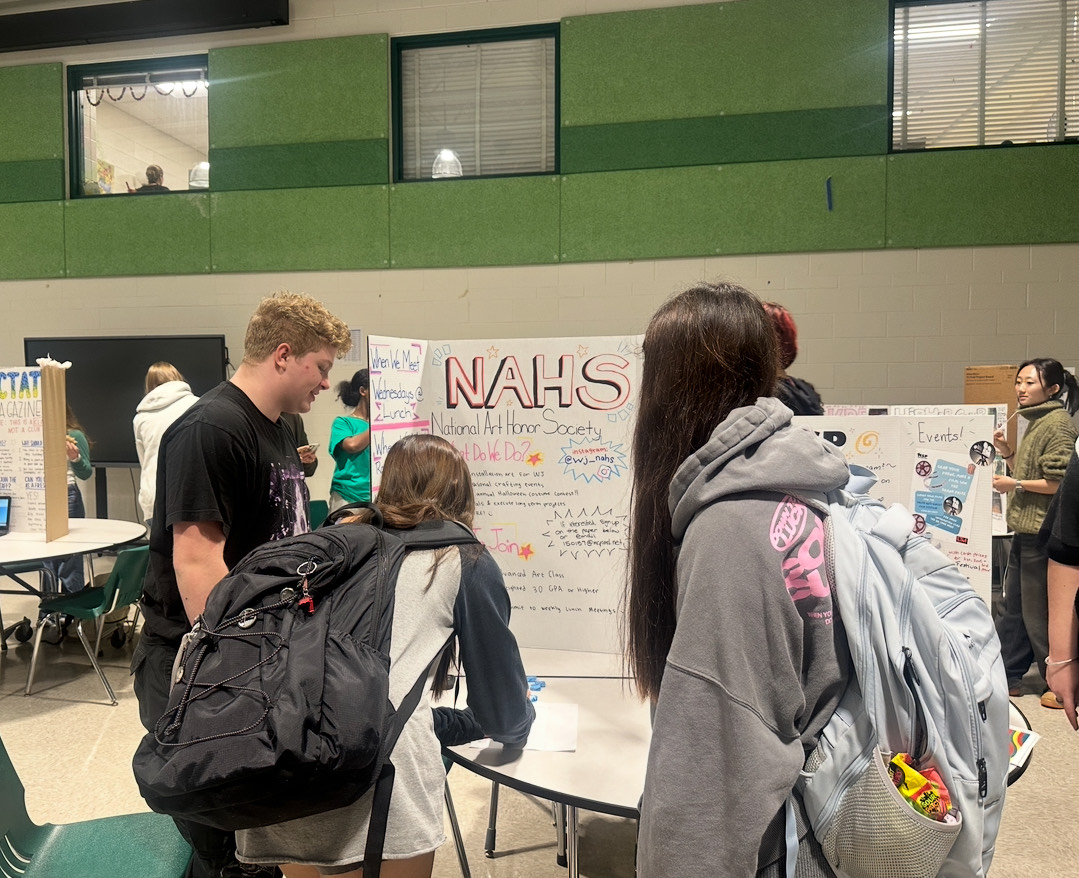 Senior and president of National Art Honor Society Ashton Hyer explains what the club is about as people sign up at the club fair. NAHS meets every Wednesday at lunch in room G83. “You get to help make public murals for the school and outside of school, possibly, and it's a lot of fun, and it's a great way to build community,” Hyer said.