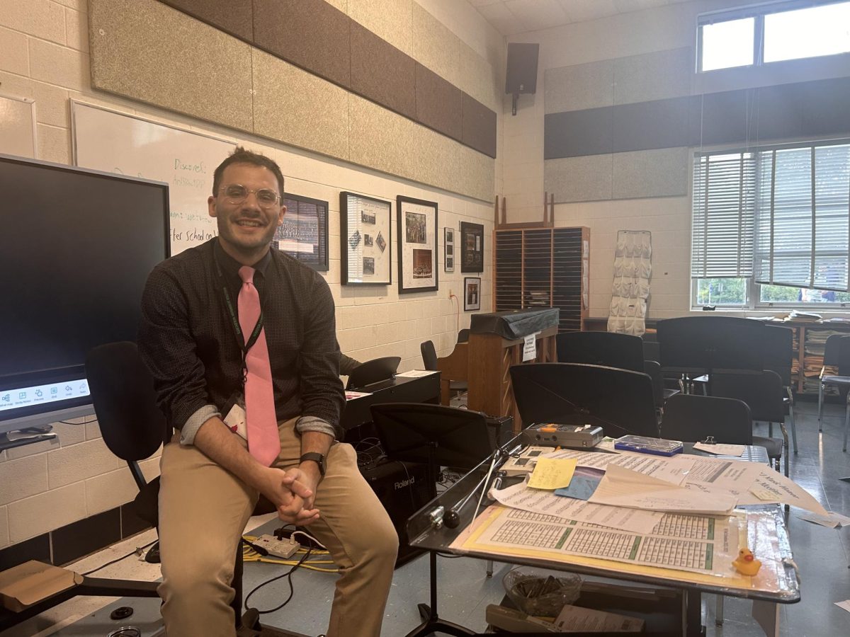 Music teacher Michael A Helgerman sits on his podium at lunch. Many students come to eat, practice their instruments and ask questions during this period.