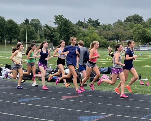 The girls' cross country team runs together as a group during a workout to prepare for their next meet. After placing fifth at states last year, the Cats will be looking to carry their success into this season and build on it. (Courtesy Sophia Barrett)