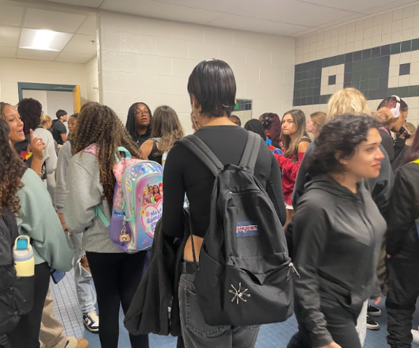 A herd of students gather in the G floor girls' bathroom before second period. Some squeeze through to wait for an open stall while others gossip and a smoke break, unconcerned by the presence of vape detectors.