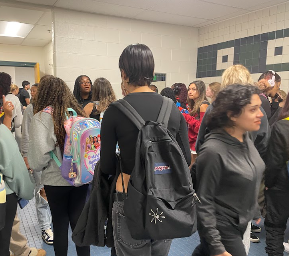 A herd of students gather in the G floor girls' bathroom before second period. Some squeeze through to wait for an open stall while others gossip and a smoke break, unconcerned by the presence of vape detectors.