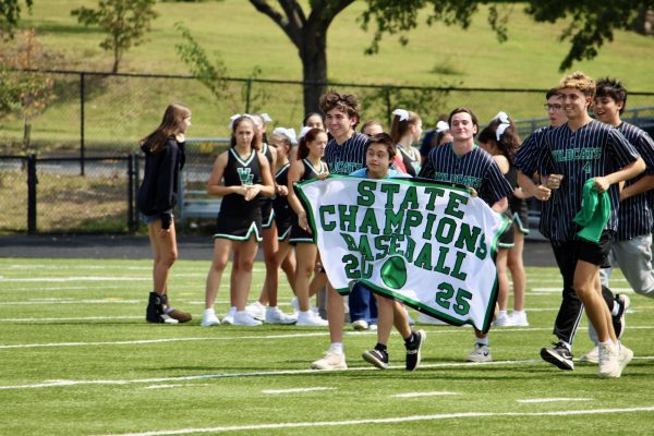 Senior Emmanuel Marquez-Castro, member of Walter Johnson's LFI program, runs with Boys' Baseball's state championship banner. The baseball received a warm welcome after their win last May in Maryland's 4A state championship.