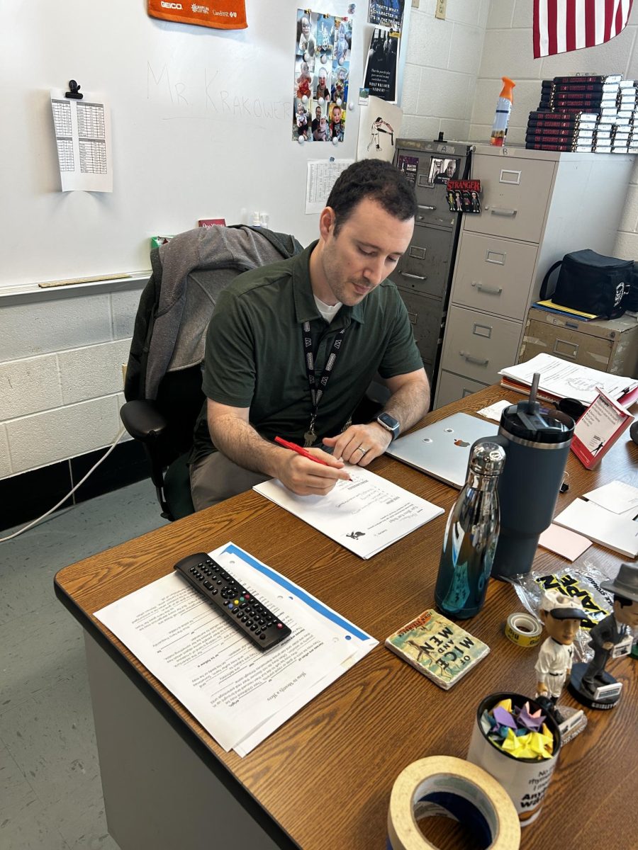 English teacher Jason Krakower grades student papers. "The new grading policy is ambitious but hopefully it will encourage students to put in their full effort throughout the semester," Krakower said. 