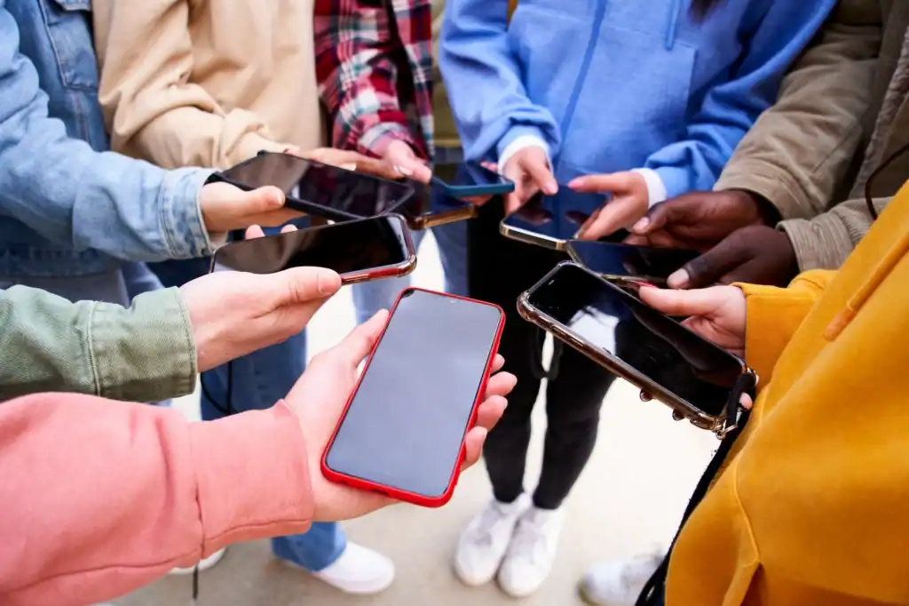 Students holding phones in a circle. MCPS has changed their take on cell phone usage, they have updated many parts of their policy in order to combat cell phone usage during school hours. (Courtesy of Asheville Recovery Center)