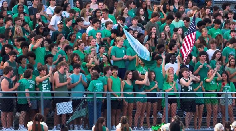 Students pack the stands at the season's first "Greenout" football game. At halftime, much of the crowd cleared out after new restrictions, such as staying off the fence and putting the flags away, were enforced. 