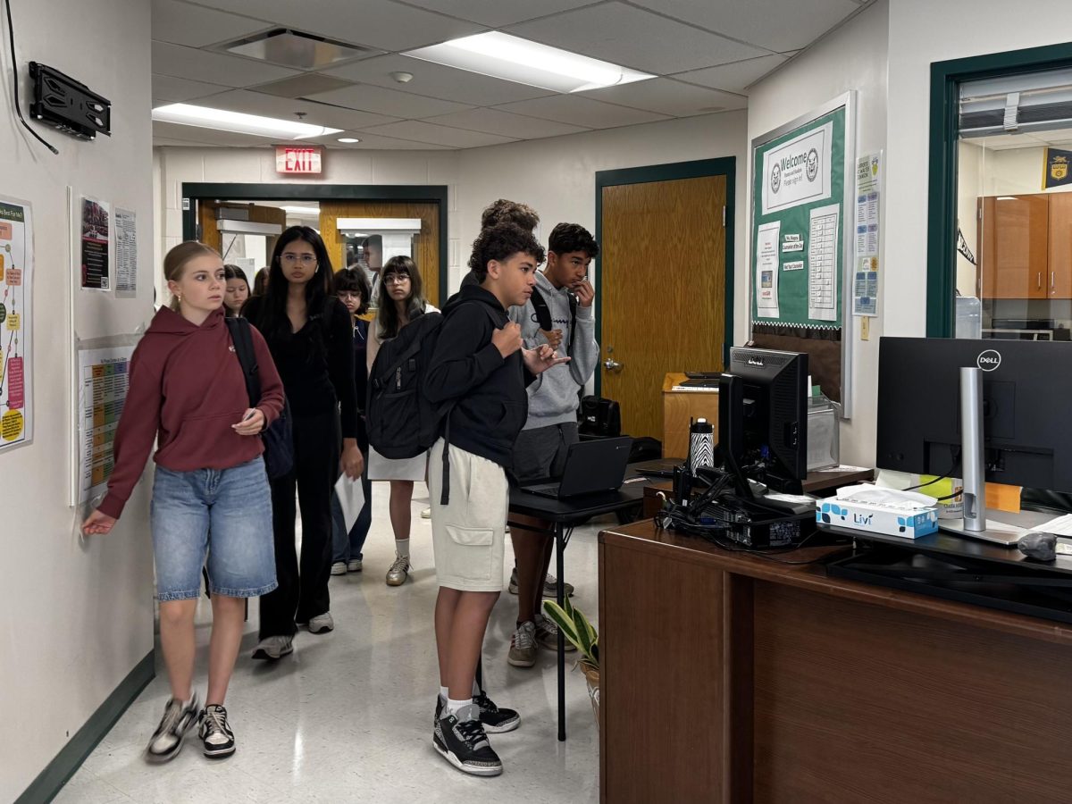 Students crowd office doors before the first bell in hopes of correcting class schedules. Students were told to wait outside office doors as a result of the large amount of people waiting to sign in.