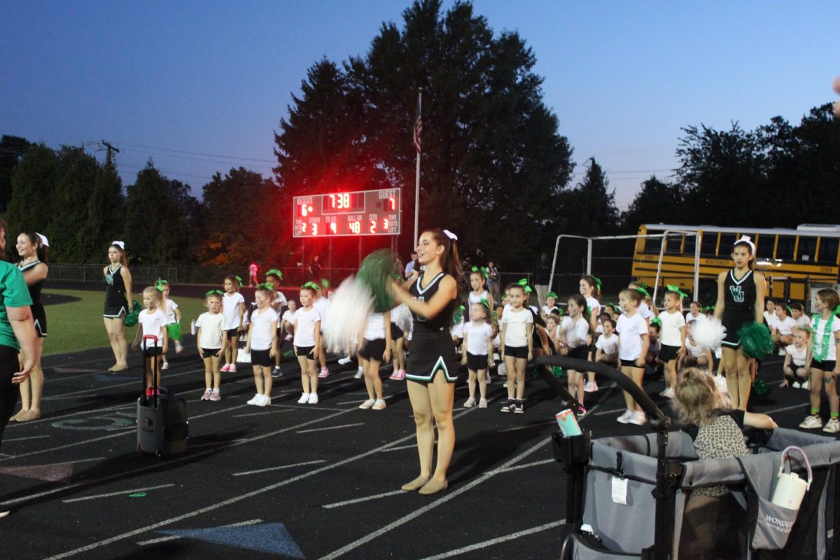 Senior Xenia Monti leads a cheer during the game with the mini poms. “It felt really good…I feel like they learned some performative skills,” Monti said. 

