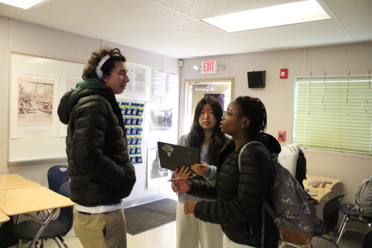 Senior vice president Kylie Hom and  volunteer coordinator Yaniso Makaya meet with senior Nathan Menendez about his outline to ensure it fits TEDx guidelines, for the event coming this January. "I think it's important because it allows people our age to have a voice in the community and to share out what we think and our opinions are," Hom said.