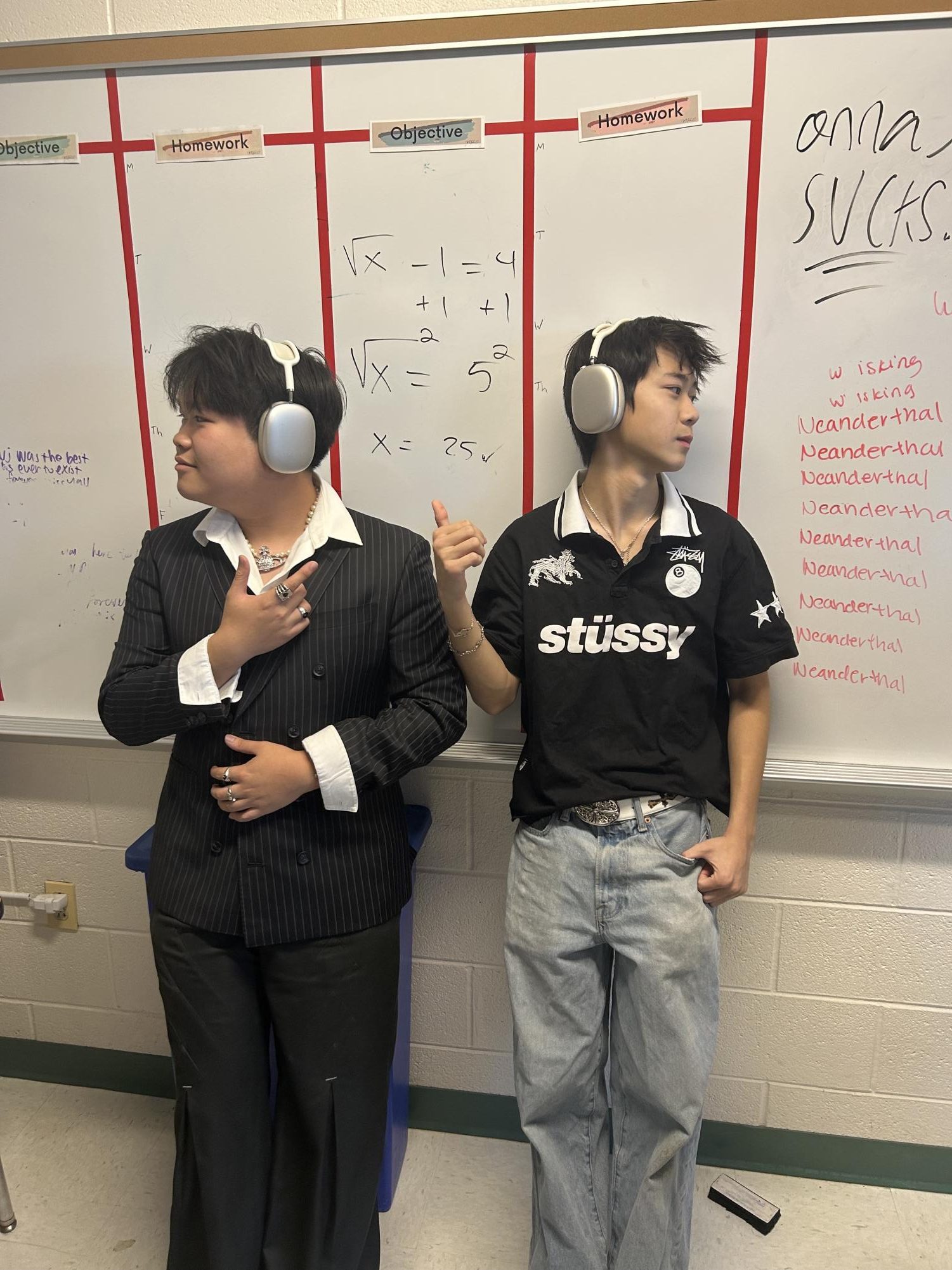 Co-Presidents of the Performative Club, Seniors Paul Do and Aidan Li, pose for a picture. Both are wearing AirPod Maxes, and various accessories, displaying their passion for performative club.