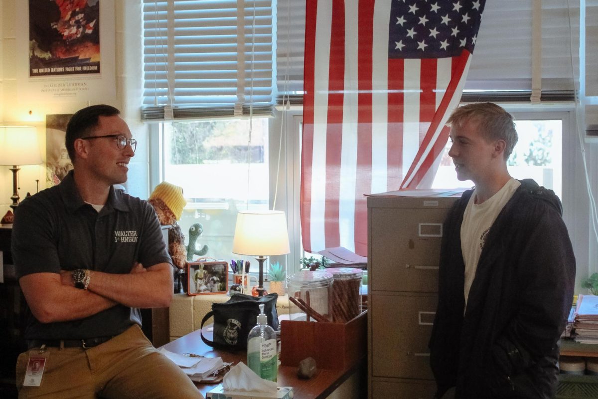 Government and law teacher Tobias Meier speaks to senior John Murphy about the government shutdown. Murphy's father was one of the thousands of government workers furloughed during the shutdown.