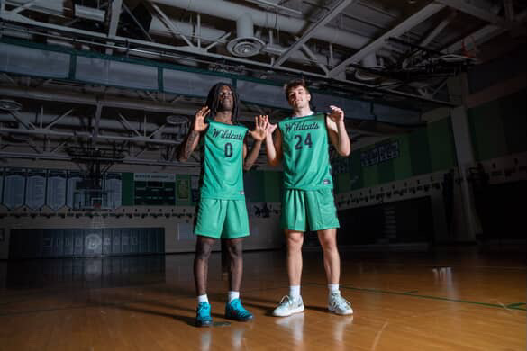 Seniors Will Kreisle and Christian Walker showcase the new Boys' Basketball uniforms during the team's media day. (Courtesy Spencer Robinson)