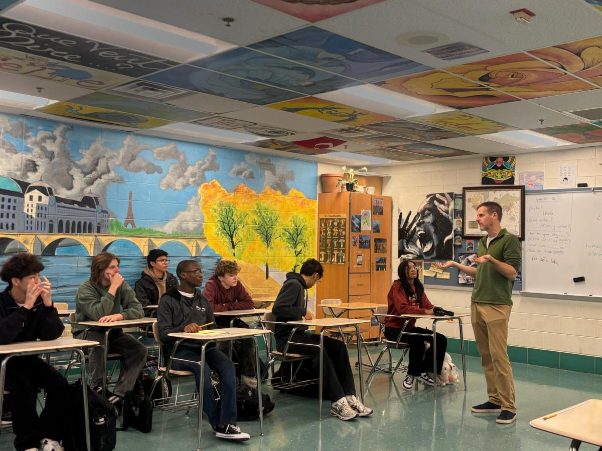Foreign language teacher Ryan Martinez lectures his class of Spanish 2 students. Martinez's colorful classroom and captivating lessons make it easier for students to remain engaged.