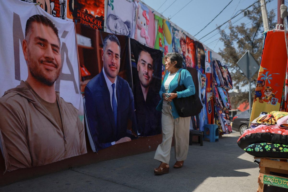 A woman looks at merchandise at street stalls selling blankets featuring Mexico's 44-year-old Security Minister Omar Garcia Harfuch, whose popularity has surged after cartel leader El Mencho's death, along a sidewalk in Ecatepec, State of Mexico, Mexico, March 12, 2026. (REUTERS/Henry Romero)