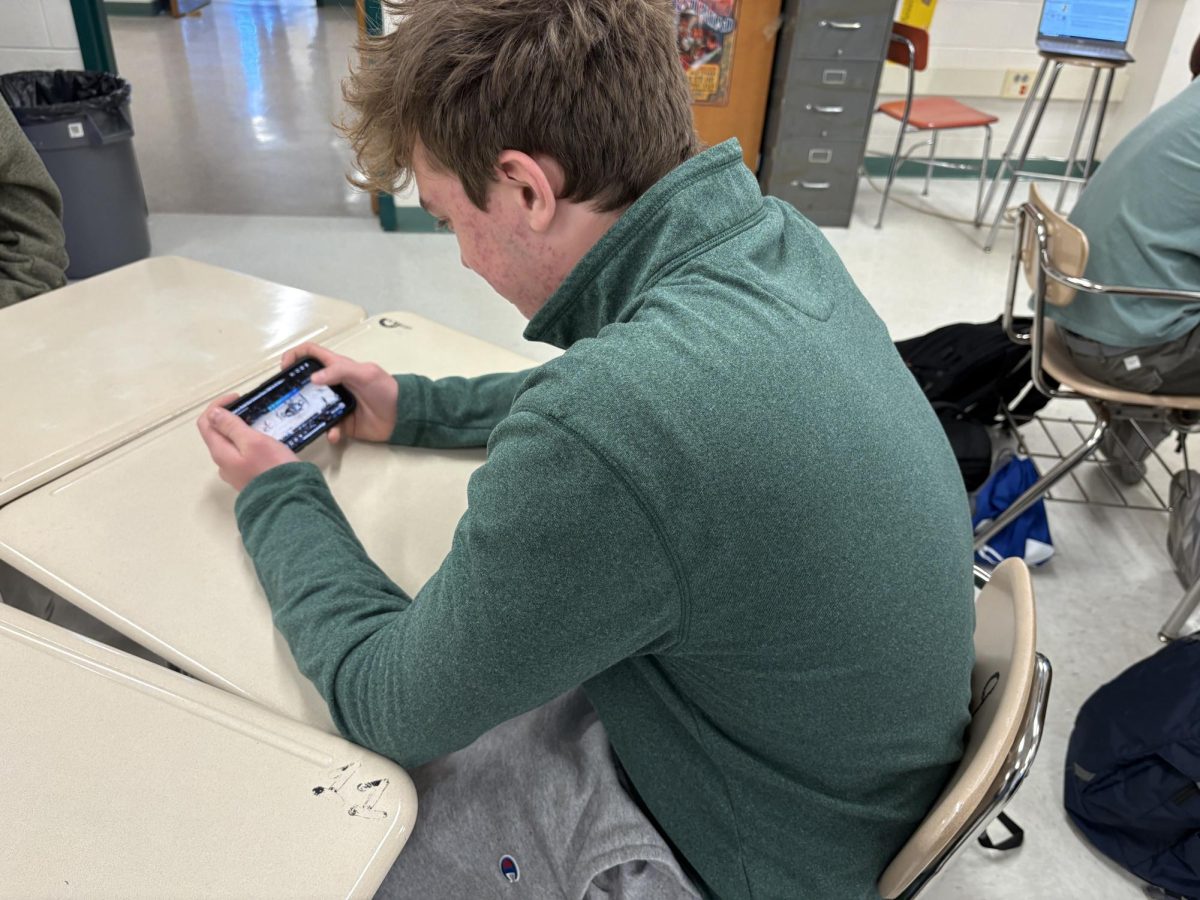 Junior Andrew Larson watches a college basketball game intensely. He, like many students, looks forward to betting on March Madness, college basketball's championship tournament.