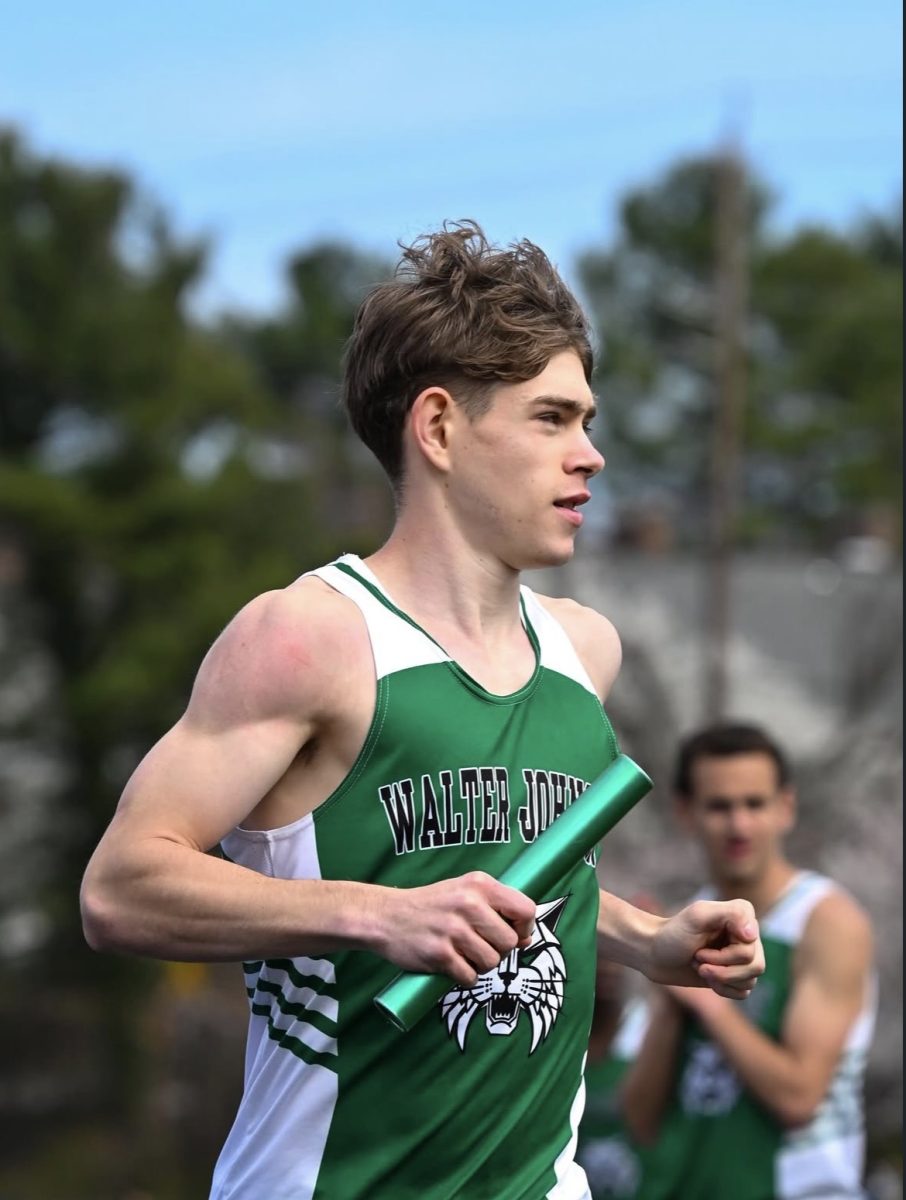 Junior Jack Fiening glides down the track against Churchill, baton in hand. Fiening won both the 400m and 800m, as well as the 4x800m relay alongside sophomores Kaius Green and Matthew Lutgendorf and senior Grant Levens. (Courtesy Jessica Cannan)