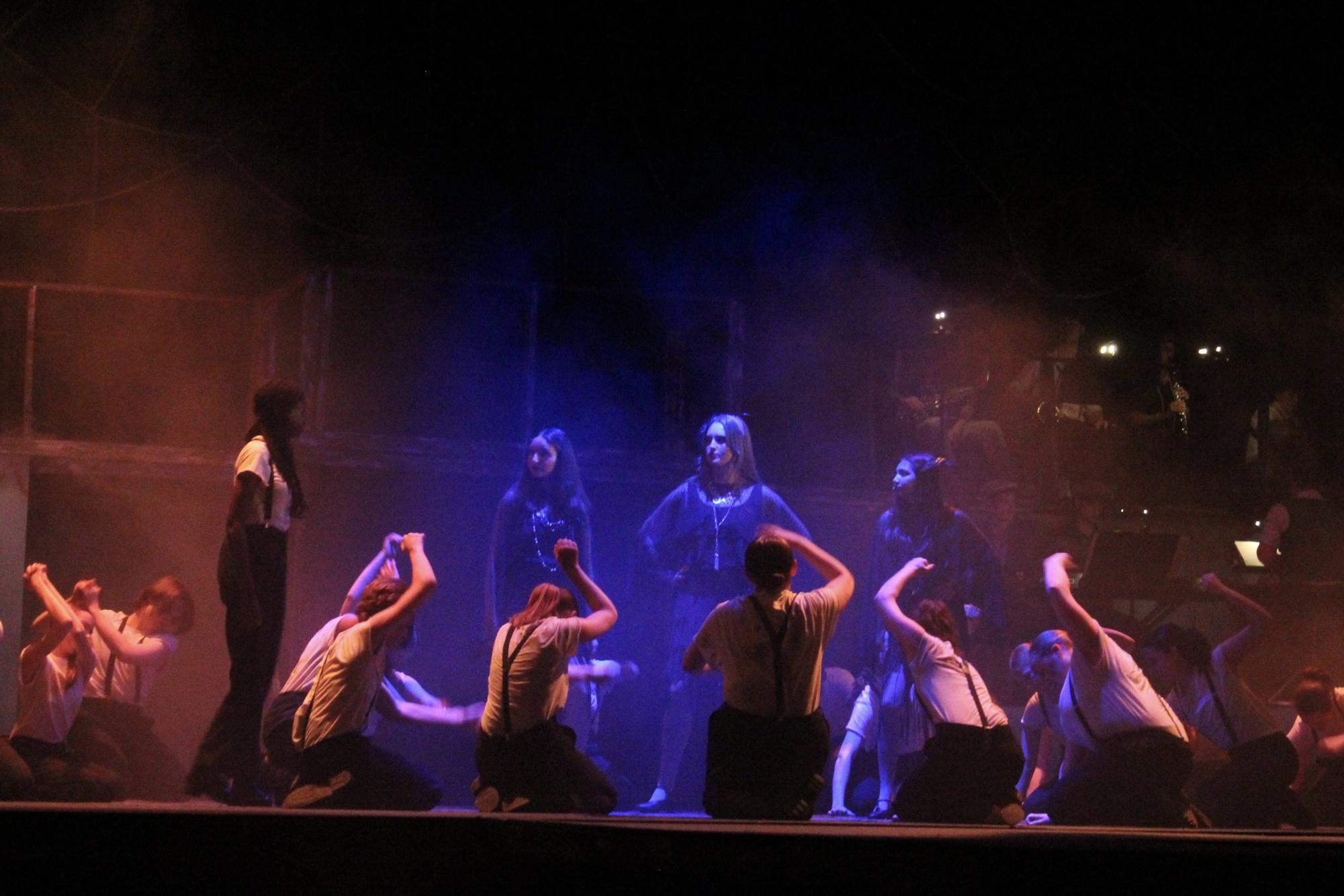 Eurydice, played by Hayley Mulema, is greeted by the fates after descending into Hadestown. As fog fills the stage, the ensemble joins together in choreographed labor, showing Eurydice the empty husk she will soon become.