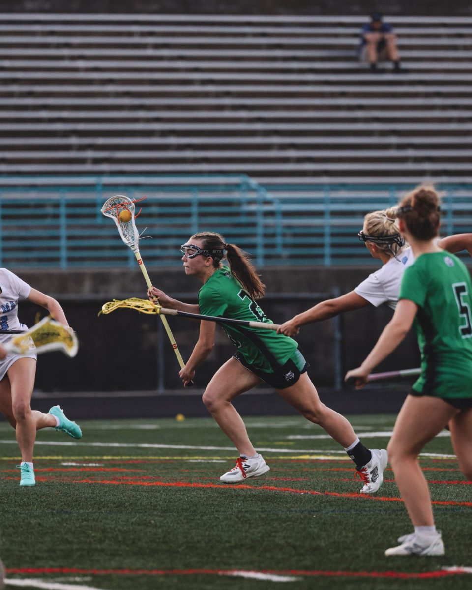 Sophomore Alina MacDermott powers through contact, maintaining possession as Whitman defenders pressure her from all angles.