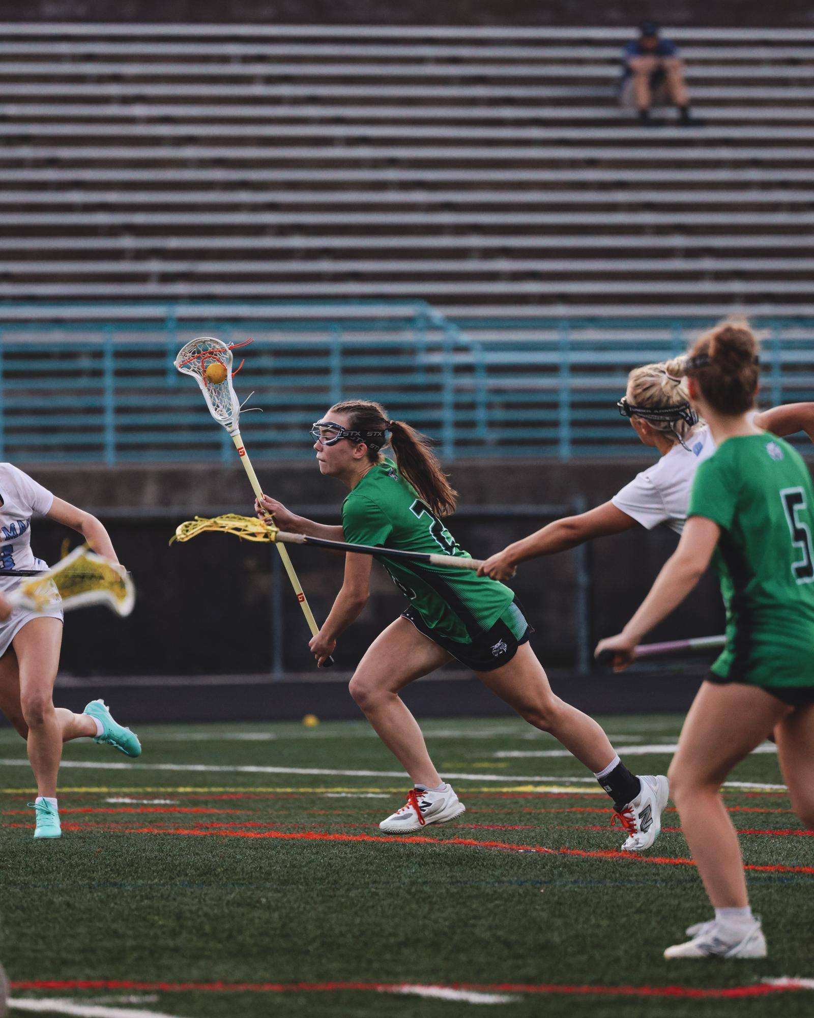 Sophomore Alina MacDermott powers through contact, maintaining possession as Whitman defenders pressure her from all angles.